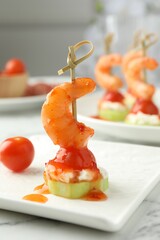 Tasty canape with shrimp, vegetables and cream cheese on white marble table, closeup
