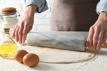 Fototapeta premium Woman rolling raw dough at table, closeup