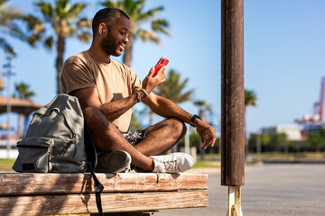 A joyful blind African young man basks in the sun at a park near the beach on a bright sunny day....