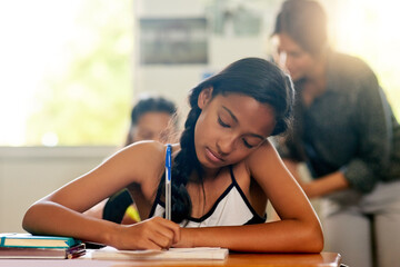 Student, girl and writing on notebook in classroom at school for education, knowledge and lesson...