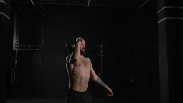 Man lifting a weight with hand, one arm dumbbell snatch, bare chest. Routine workout for physical and mental health.