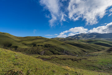 Behold the captivating panoramic view of the expansive grasslands amidst the mountains of Bajura, Nepal during the enchanting autumn season.