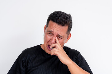 Naklejka premium A man removes Rheum or eye discharge from his tear duct. Isolated on a white background. Possible conjunctivitis, sty or other infection.
