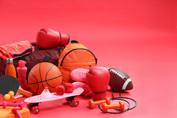 Many different sports equipment on red background, space for text