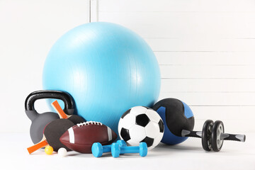 Many different sports equipment on white table