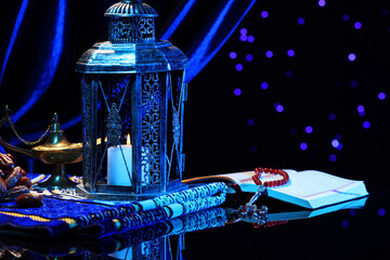 Arabic lantern, Quran, misbaha, Aladdin magic lamp, dates and folded prayer mat on mirror surface...