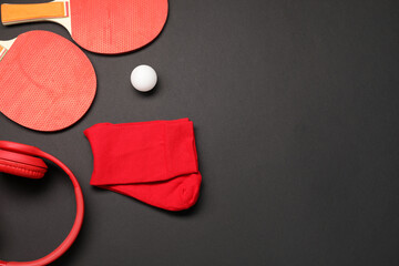 Sports equipment. Ping pong rackets, ball, headphones and socks on black background, flat lay....