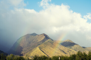 double rainbow over volcano mountains with clouds sky background at Hawaii, USA.