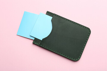 Leather business card holder with blank cards on pink background, top view