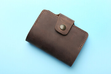 Stylish leather card holder on light blue background, top view