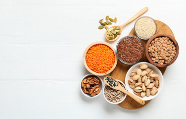 Different products high in natural fats on white wooden table, flat lay. Space for text