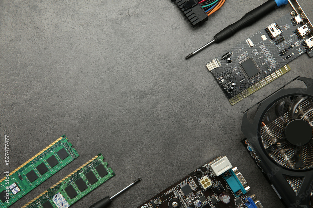 Fototapete graphics card and other computer hardware on grey textured table, flat lay. space for text