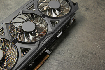One computer graphics card on grey textured table, closeup. Space for text