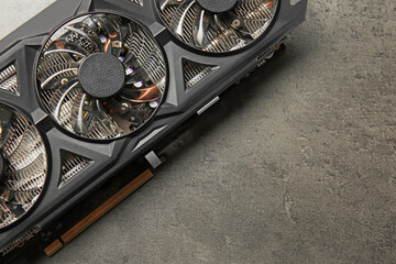 One computer graphics card on grey textured table, top view. Space for text