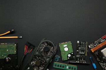 Graphics card and other computer hardware on black background, flat lay. Space for text
