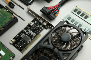 Graphics card and other computer hardware on gray textured background, above view