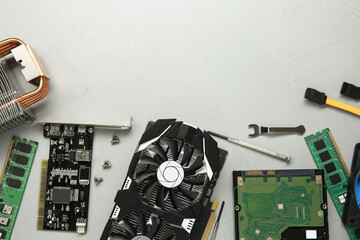 Graphics card and other computer hardware on gray textured background, flat lay. Space for text