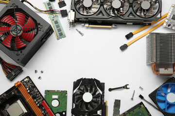 Frame of graphics card and other computer hardware on white background, flat lay. Space for text