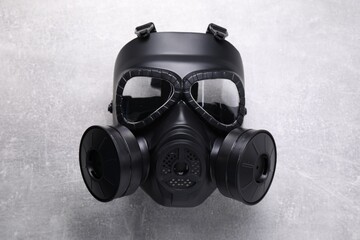 One gas mask on grey textured background, top view