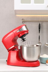 Modern red stand mixer on white table in kitchen