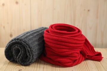 Red and gray knitted scarfs on wooden table