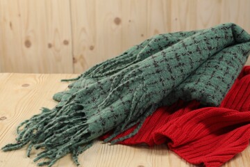 Soft green and red scarfs on wooden table