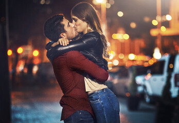 Man, woman and kiss at night in street for support, care and marriage with commitment. Happy,...