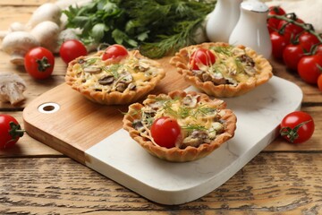 Tasty tartlets with cheese, tomatoes and dill on wooden table, closeup