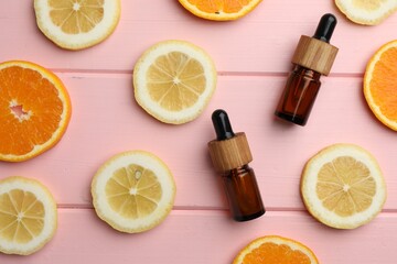 Aromatherapy. Different essential oils and citrus fruits on pink wooden table, flat lay
