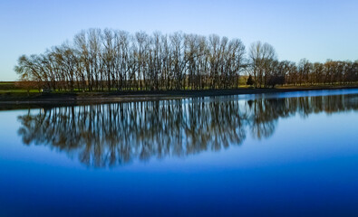 Scenic view, Reflection of trees in the calm water of a small lake