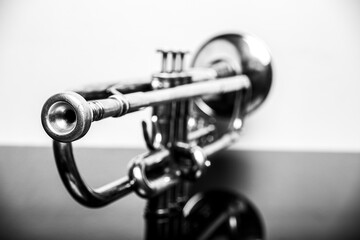 Classical trumpet on black glass table with white background; perfect shot for music lovers...