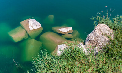 Large granite stones in the water of a flooded granite quarry, Ukraine
