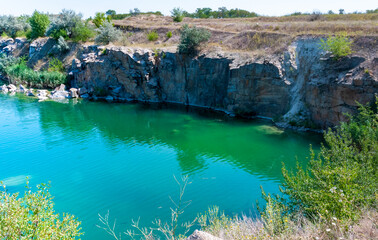 View of the flooded granite quarry with turquoise clear water, Ukraine