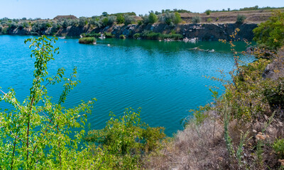 View of the flooded granite quarry with turquoise clear water, Ukraine