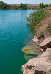 Obraz premium View of the flooded granite quarry with turquoise clear water, Ukraine