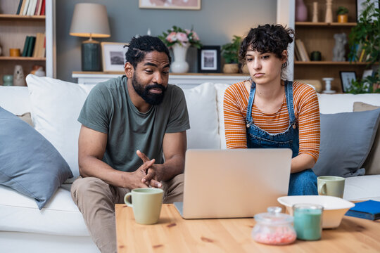 Young couple attending online psychology educational class on laptop via webcam. Newlywed man and woman having video call with psychologist or family member, using computer for distant communication.