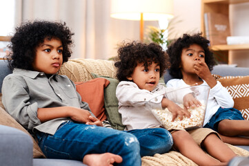 Children, couch and watching tv with popcorn in home or streaming movie, subscription or cartoon....
