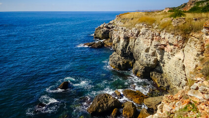 Storm at Black sea. Big waves break on the rocky shore, white foam on the water