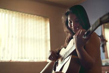 Guitar, art and woman musician on bed learning song for performance, recital or concert. Musical...