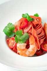 Classic homemade pasta with colored tagliatelli, cherry tomatoes