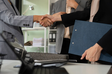 Happy businessman and businesswoman shaking hands at group board meeting. Professional business...