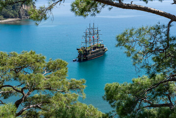 Fototapeta premium Wandern in der Türkei: Lykischer Weg, Küstenwanderung an der türkischen Riviera mit schönen Ausblicken - Piraten Schiff, Boot in der Bucht von Phaselis