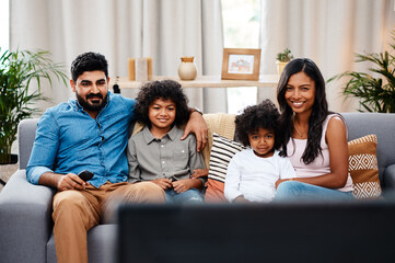 Mom, dad and children in living room watching tv on sofa with happy family, bonding together and...