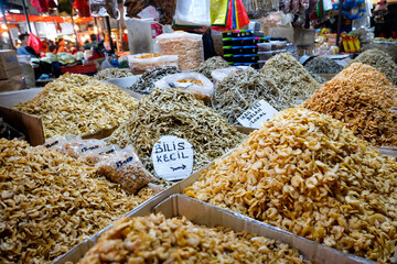 various anchovies displayed at traditional market. various kinds of dried anchovies and shrimps in...