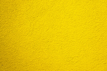 Close-up of a yellow plastered wall. The surface of the coating is rough. Background. Texture