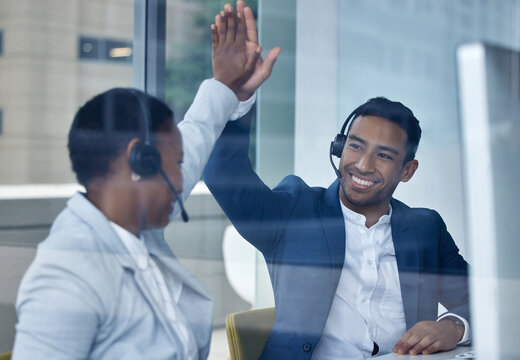 High five, call centre agent and success for coworker in office, sale and achievement for target. Telemarketing, victory and support of colleague, headphones or customer service man and female person