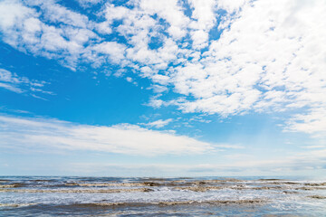 Wavy sea and blue sky with clouds