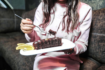 Woman Holding a Plate With a Slice of Cake