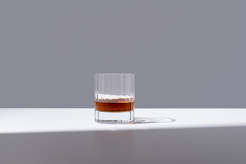 Un vaso de whisky escocés sobre un fondo gris	