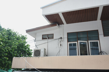 The balcony of a modern business building houses an air conditioner.